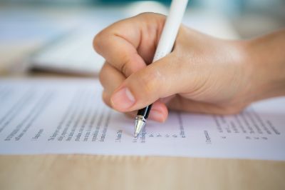 mano-con-una-penna-che-scrive-su-un-documento
